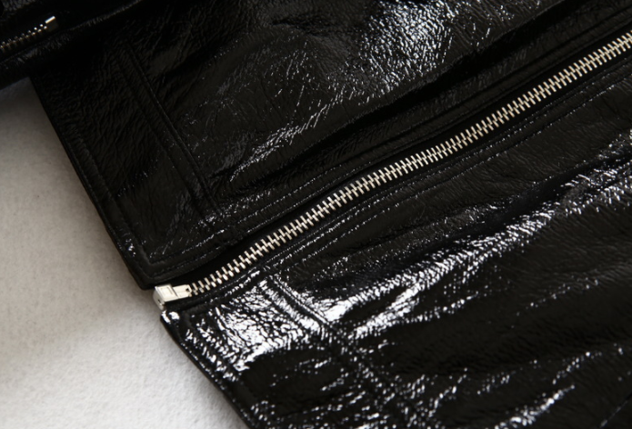 Woman wearing black short motorcycle leather jacket outdoors