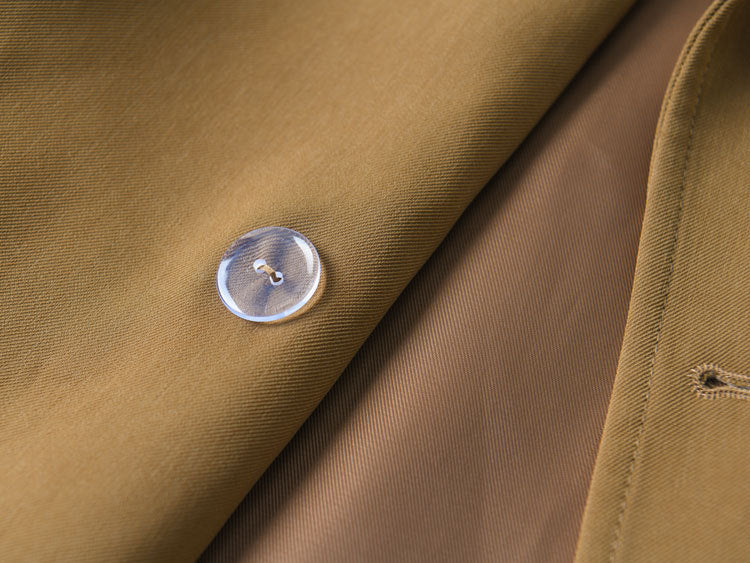 Woman wearing khaki short trench coat with long sleeves