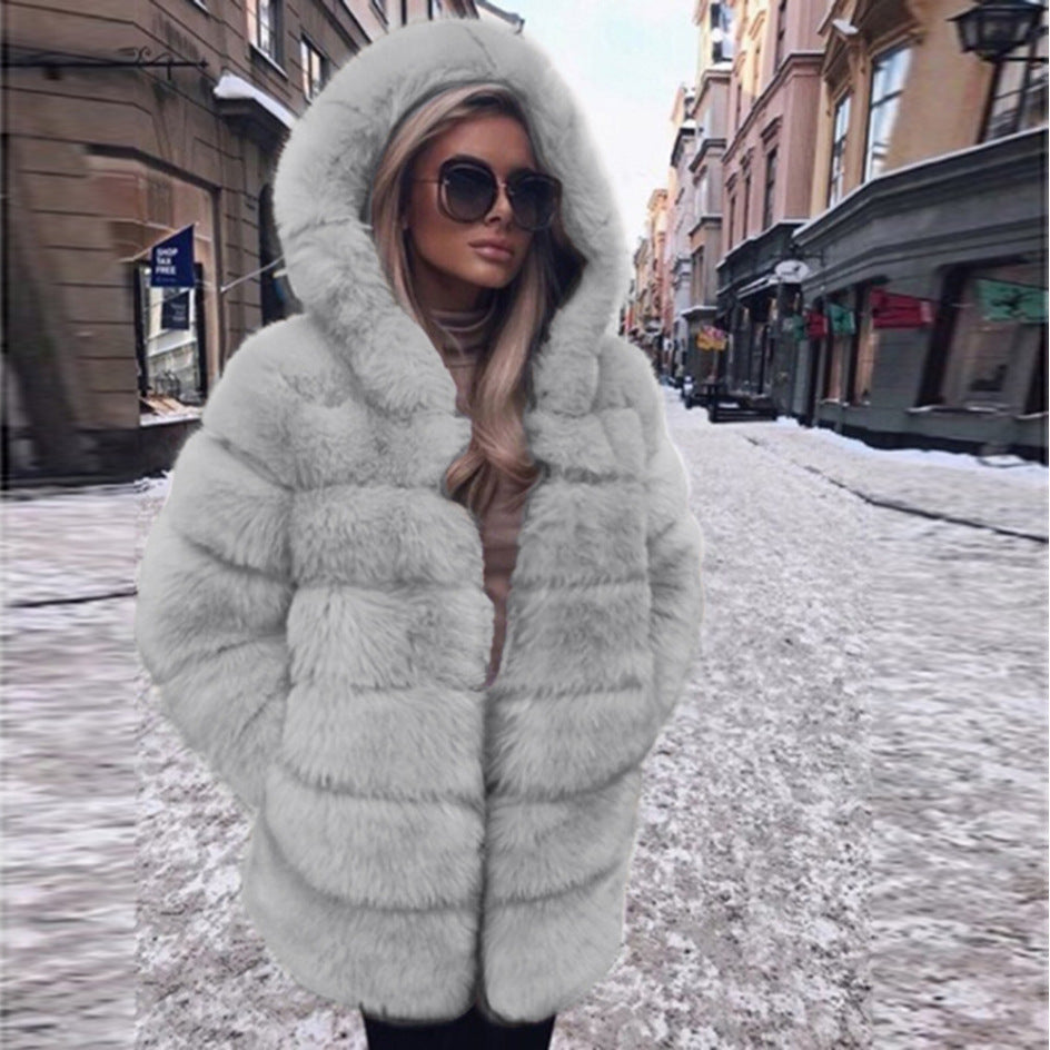 Woman wearing a fluffy faux fur short coat with hood