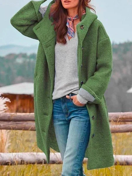 Woman wearing long hooded coat with button front