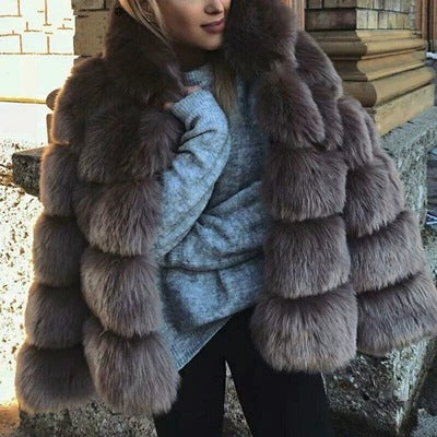 Woman wearing a fluffy faux fur short coat with hood