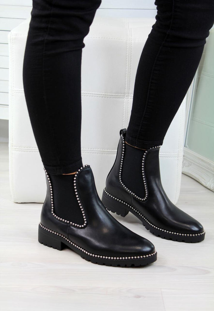 Woman wearing black short martin boots with round toe