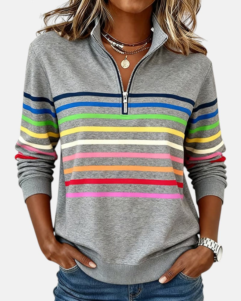 Woman wearing rainbow striped zip sweatshirt with stand collar