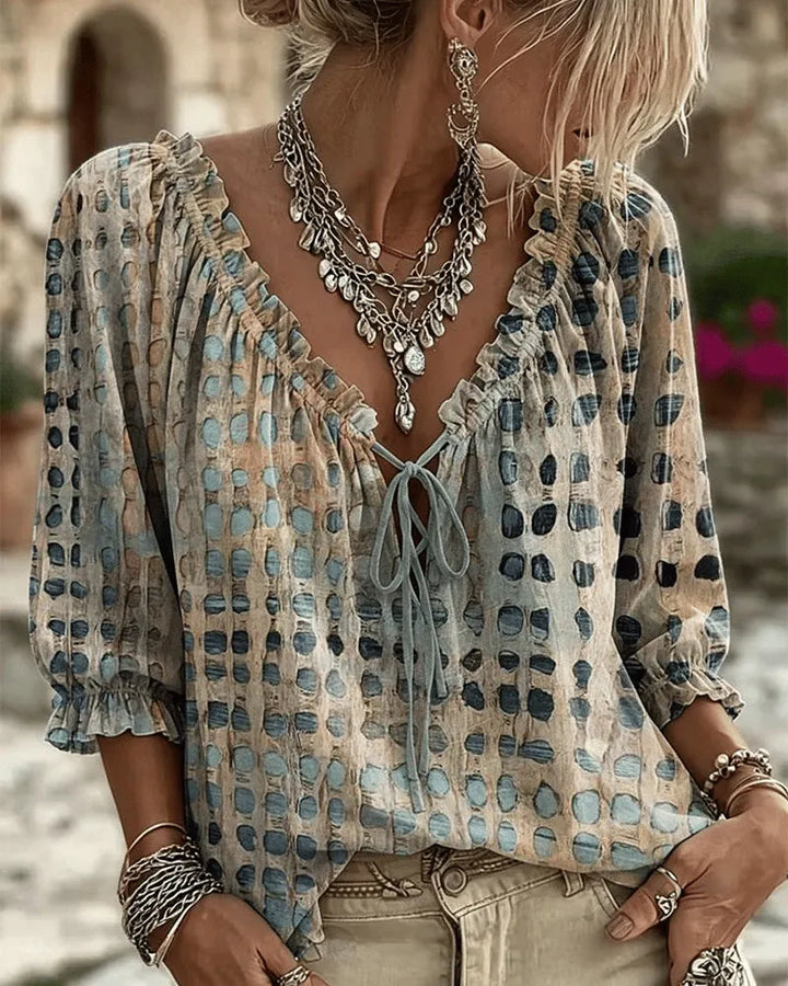 Woman wearing polka dot blouse with lace-up V-neck