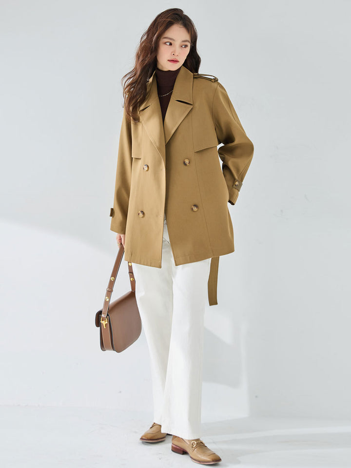 Woman wearing khaki short trench coat with long sleeves