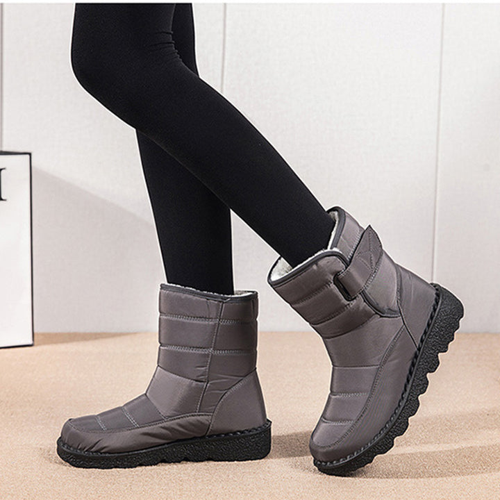 Woman wearing black plush-lined snow boots with buckle