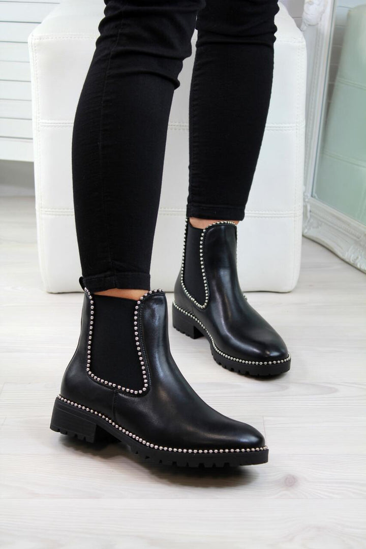 Woman wearing black short martin boots with round toe