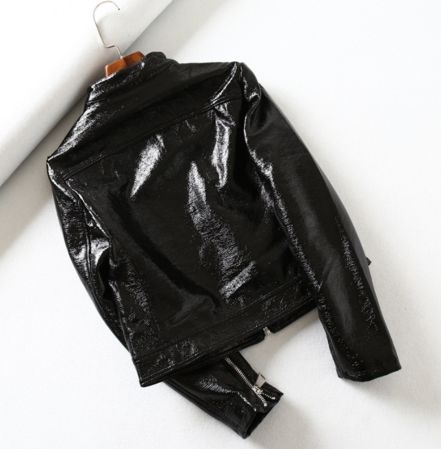 Woman wearing black short motorcycle leather jacket outdoors