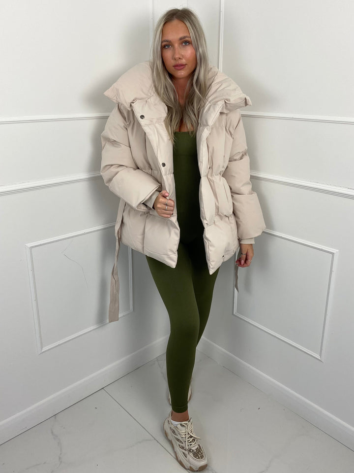 Woman wearing quilted puffer jacket with belt