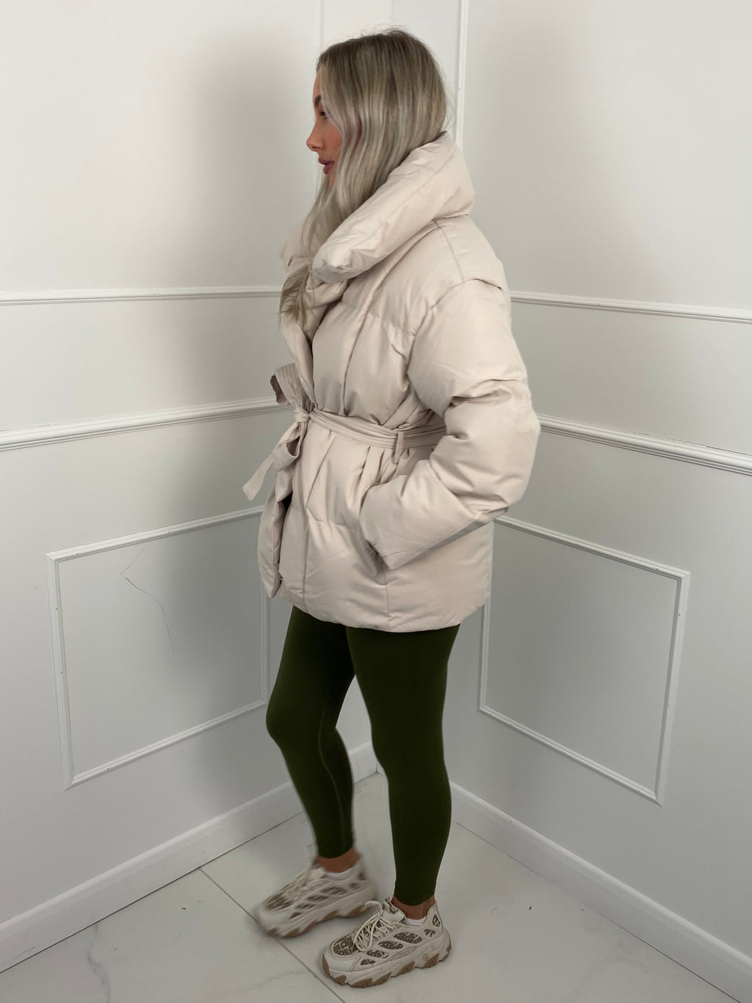 Woman wearing quilted puffer jacket with belt