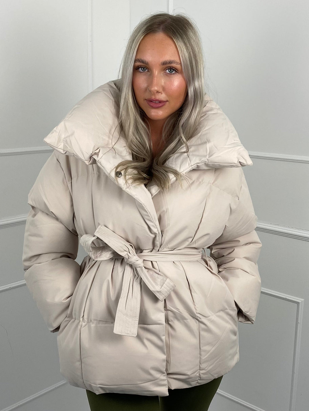 Woman wearing quilted puffer jacket with belt