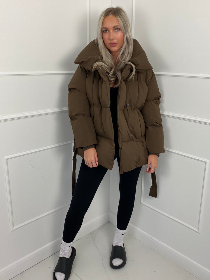 Woman wearing quilted puffer jacket with belt