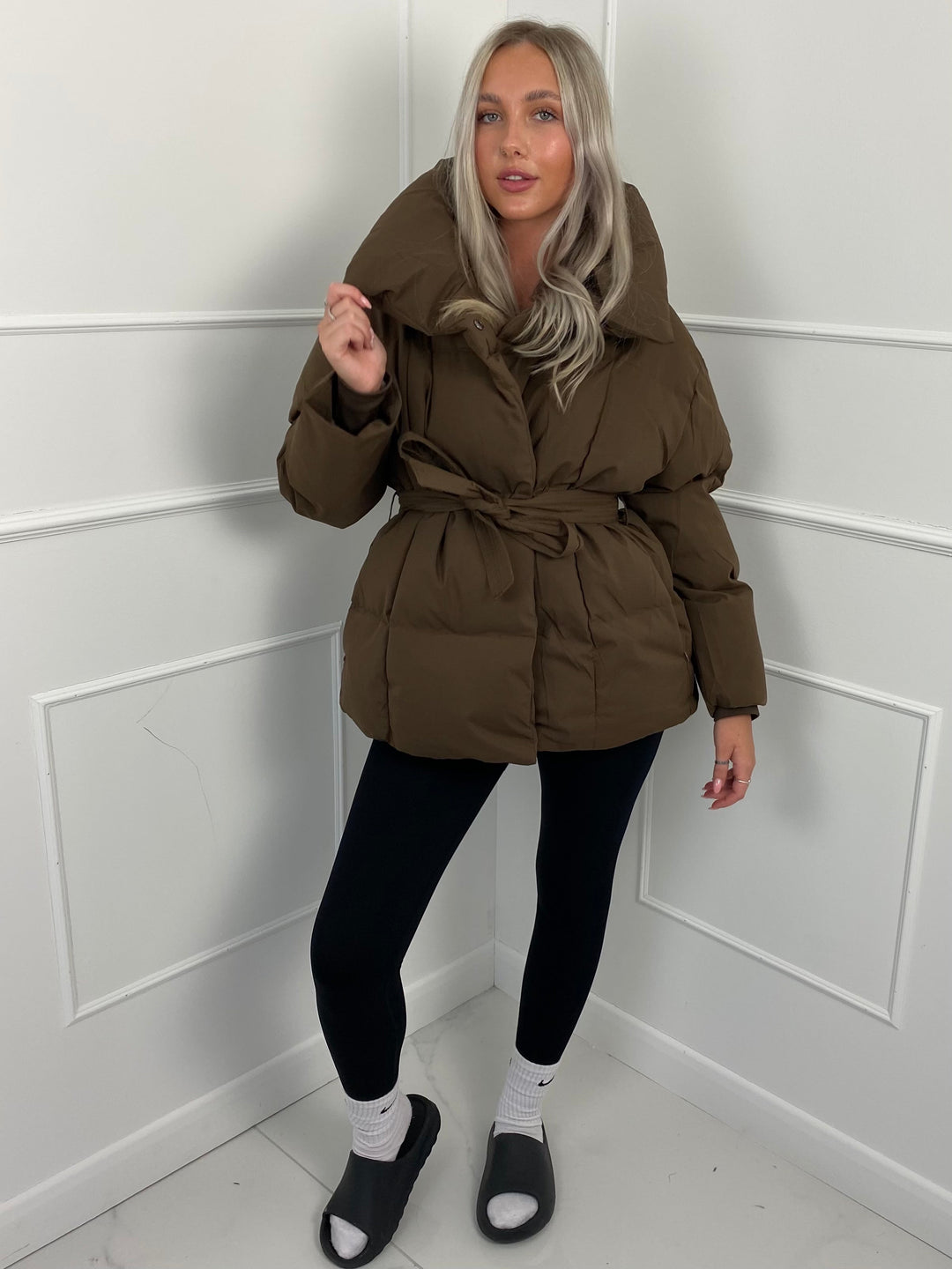 Woman wearing quilted puffer jacket with belt