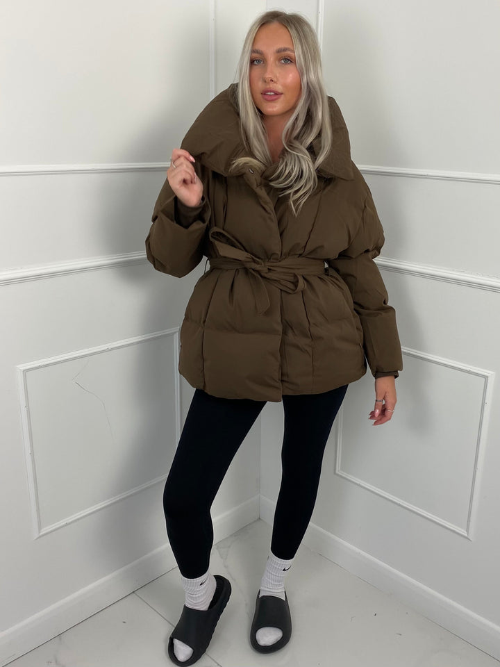 Woman wearing quilted puffer jacket with belt