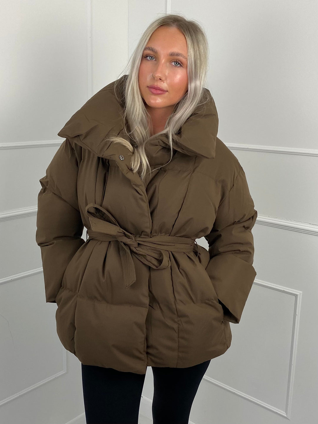 Woman wearing quilted puffer jacket with belt
