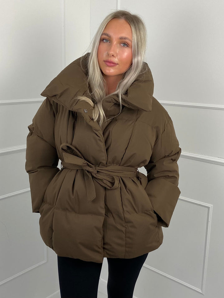 Woman wearing quilted puffer jacket with belt