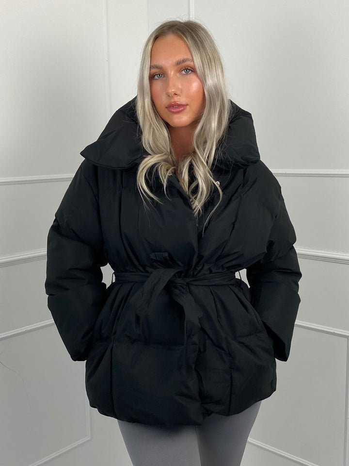 Woman wearing quilted puffer jacket with belt