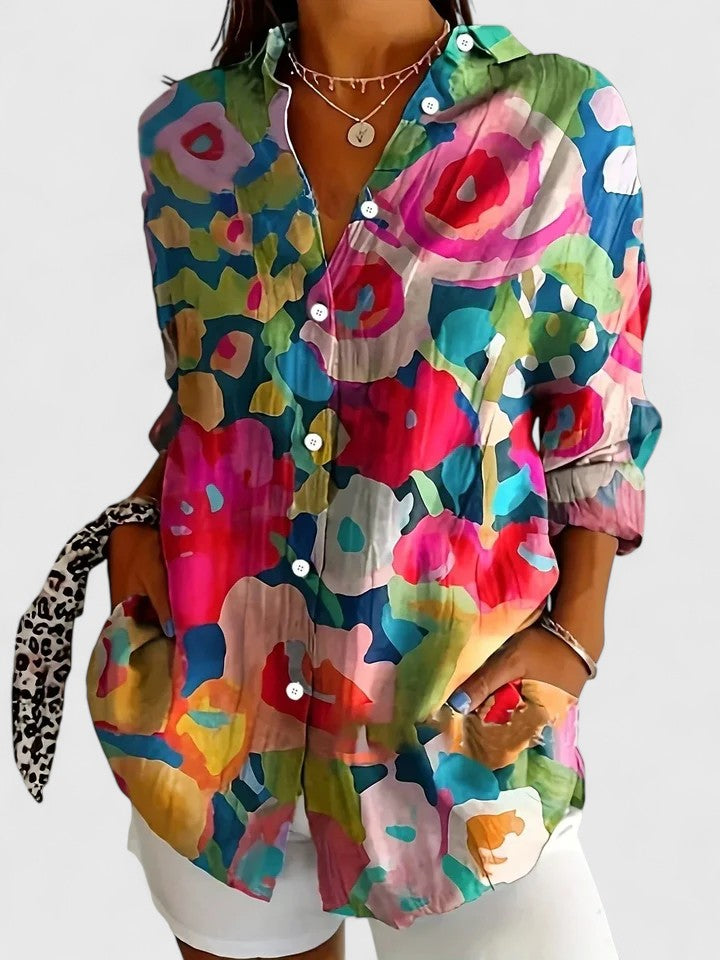 Woman wearing artistic print button-up blouse in bright colors
