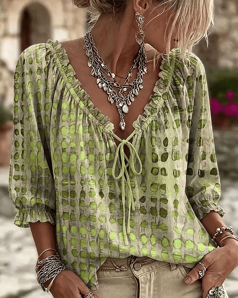 Woman wearing polka dot blouse with lace-up V-neck