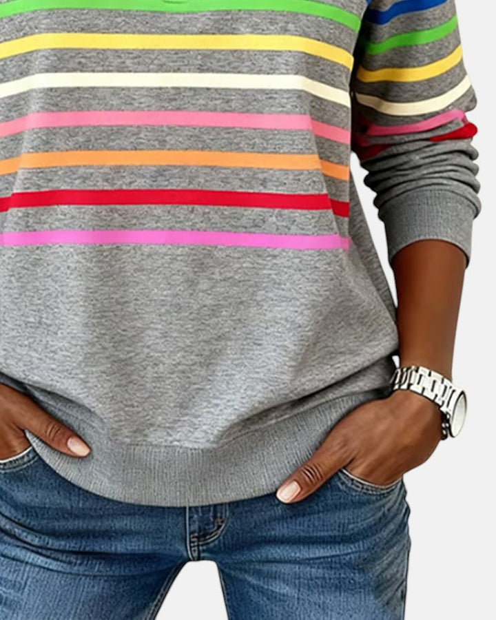 Woman wearing rainbow striped zip sweatshirt with stand collar