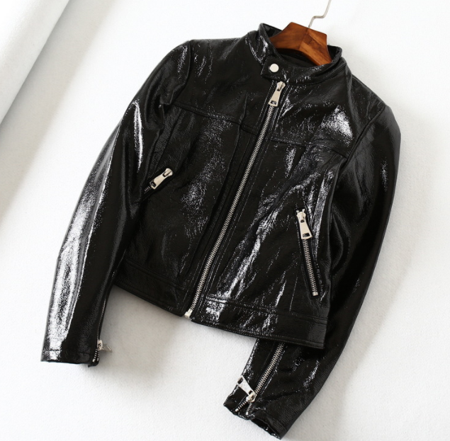 Woman wearing black short motorcycle leather jacket outdoors