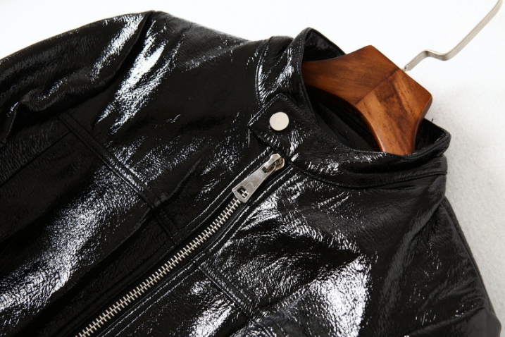 Woman wearing black short motorcycle leather jacket outdoors