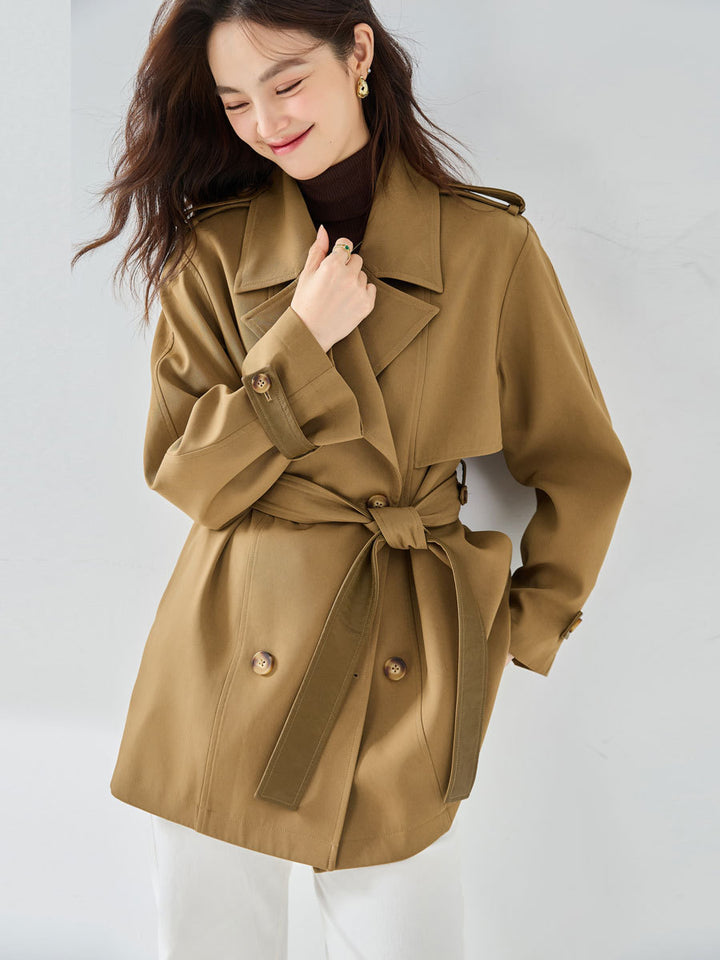 Woman wearing khaki short trench coat with long sleeves