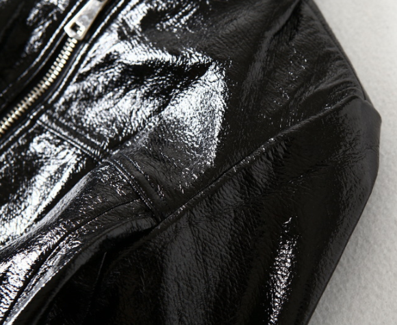 Woman wearing black short motorcycle leather jacket outdoors