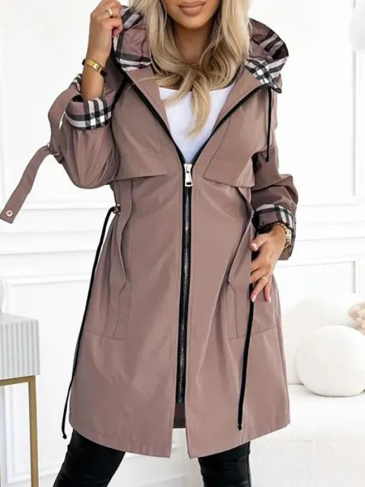 Woman wearing long coat with checked hood