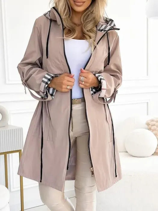 Woman wearing long coat with checked hood